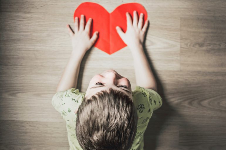 Child with heart shaped paper