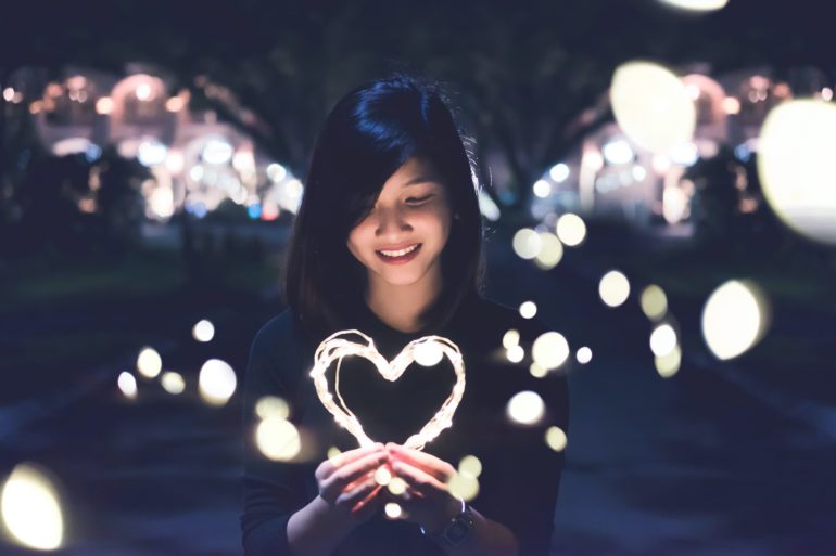 Girl holding heart shaped light