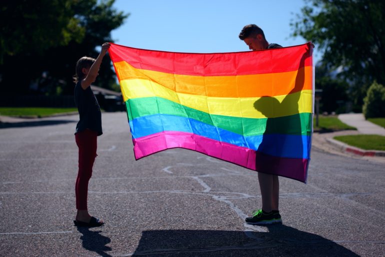 Woman and child holding rainbow flag