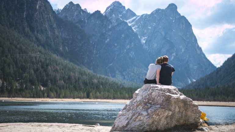 Couple sitting on a rock at a lake