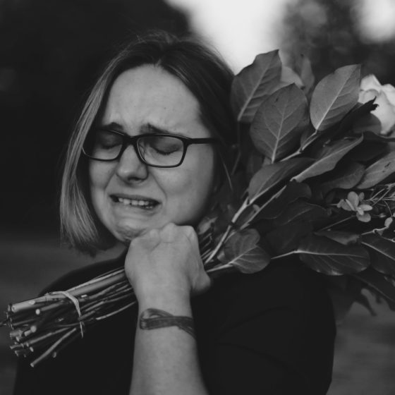 Crying woman holding flowers