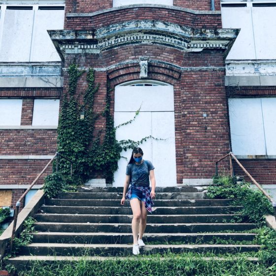 Girl in mask in front of closed school