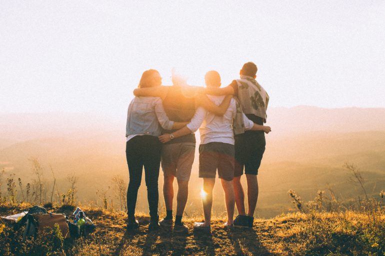 Friends hugging at sunset