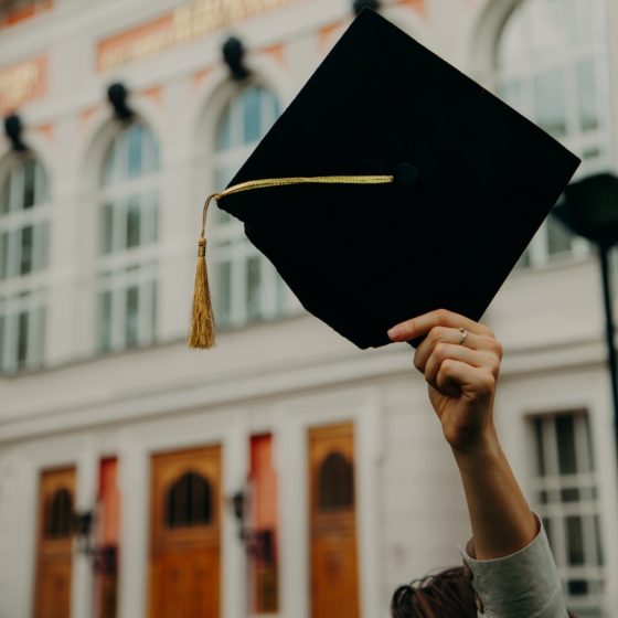 Hand holding a graduation cap