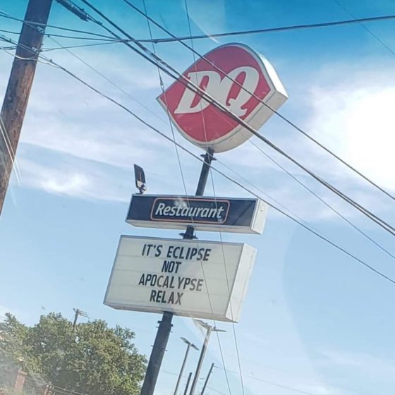 DQ sign reading "It's eclipse not apocalypse relax"